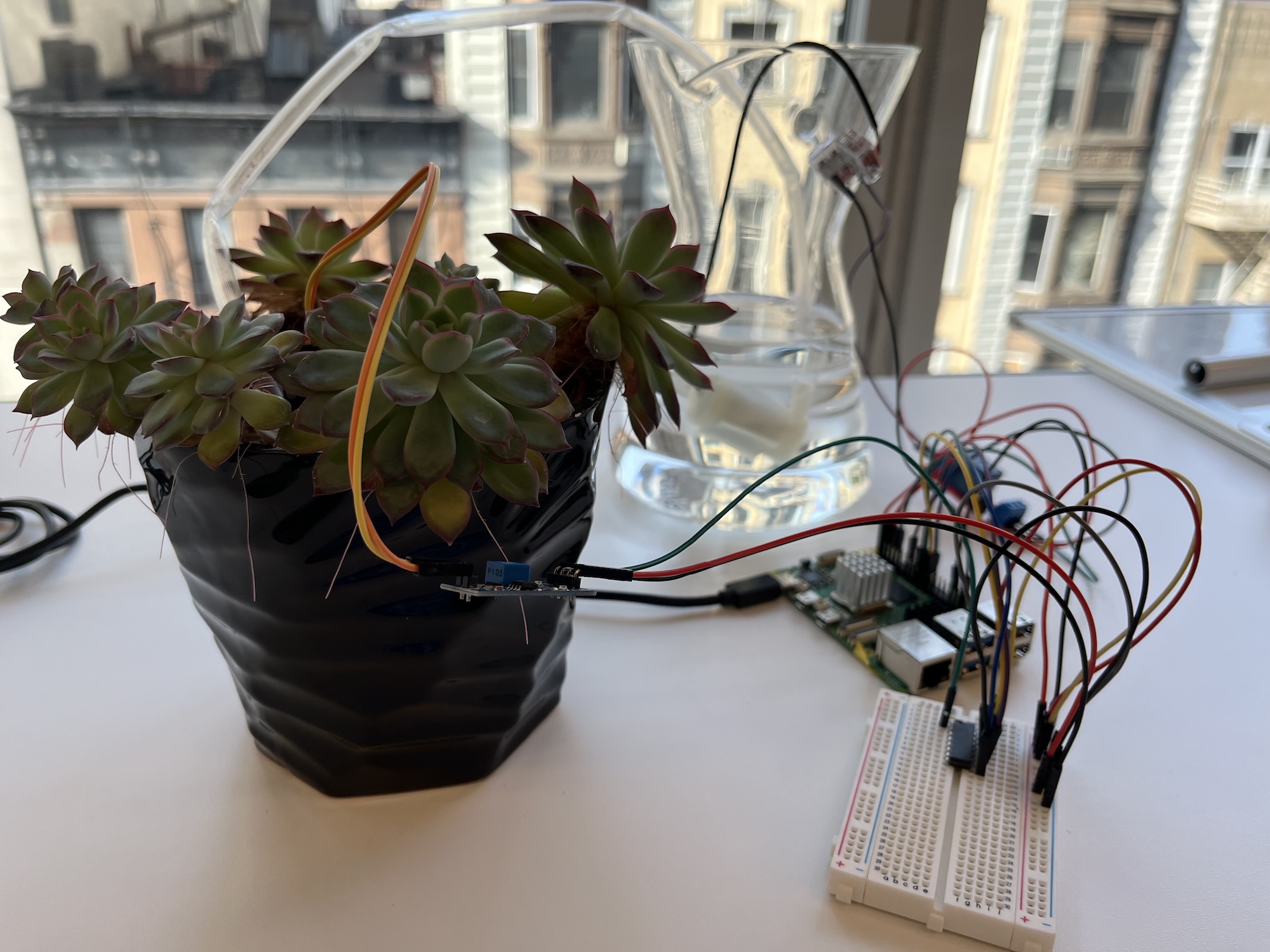 Picture of the plant watering machine on a desk.